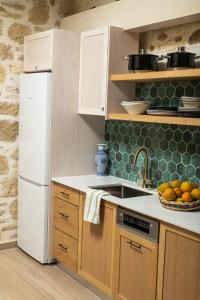 een keuken met een witte koelkast en een wastafel bij Beit Petra in Daratso