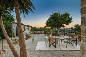een patio met een tafel en stoelen en palmbomen bij Beit Petra in Daratso