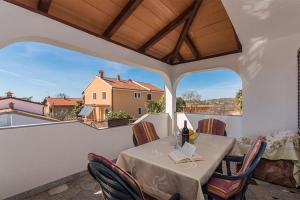 d'une salle à manger avec une table et des chaises sur un balcon. dans l'établissement Apartments with a parking space Novigrad - 2536, à Novigrad