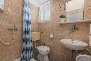 La salle de bains est pourvue de toilettes et d'un lavabo. dans l'établissement Apartments with a parking space Novigrad - 2536, à Novigrad