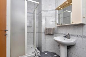 La salle de bains blanche est pourvue d'un lavabo et d'une douche. dans l'établissement Apartments and rooms by the sea Baska Voda, Makarska - 2578, à Baška Voda