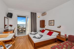 a hotel room with a bed and a table and chairs at Apartments and rooms by the sea Baska Voda, Makarska - 2578 in Baška Voda