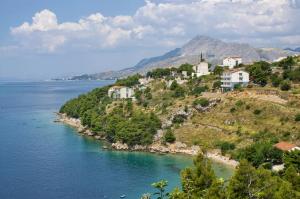 a village on a hill next to the water at Apartments by the sea Nemira, Omis - 4277 in Tice