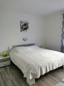 a bedroom with a large white bed and a wooden floor at Apartments with a parking space Kampor, Rab - 4985 in Kampor
