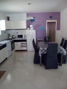a kitchen with a table and a kitchen with purple walls at Apartments with a parking space Kampor, Rab - 4985 in Kampor