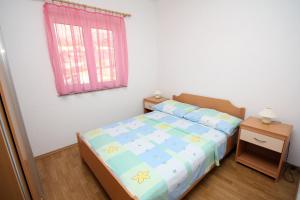um pequeno quarto com uma cama e uma janela em Apartments with WiFi Seget Vranjica, Trogir - 4870 em Trogir