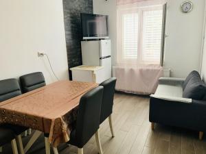 ein Esszimmer mit einem Tisch, Stühlen und einem TV in der Unterkunft Apartments with a parking space Sobra, Mljet - 4926 in Babino Polje