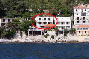 a large house with a red circle in front of it at Apartments by the sea Sobra, Mljet - 4889 in Babino Polje