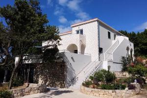 a white building with stairs in front of it at Apartments by the sea Kozarica, Mljet - 4950 in Kozarica