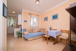 a living room with a blue couch and a table at Apartments by the sea Barbat, Rab - 4967 in Barbat na Rabu
