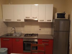 a kitchen with red cabinets and a stainless steel refrigerator at Apartments by the sea Cove Blaca, Mljet - 4899 in Saplunara