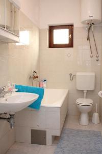 Baño blanco con lavabo y aseo en Apartments with a parking space Lokva Rogoznica, Omis - 4819 en Lokva Rogoznica