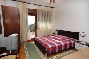 1 dormitorio con 1 cama, TV y ventana en Apartments with a parking space Lokva Rogoznica, Omis - 4819 en Lokva Rogoznica