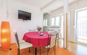 a dining room with a red table and chairs at Apartments with a parking space Palit, Rab - 4990 in Rab