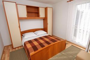 a small bedroom with a bed and a window at Apartments with parking space Banjol, Rab - 4956 in Rab