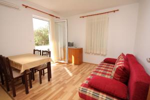a living room with a red couch and a table at Apartments with parking space Banjol, Rab - 4956 in Rab