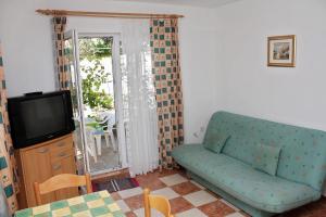 a living room with a couch and a tv at Apartments with parking space Banjol, Rab - 4956 in Rab