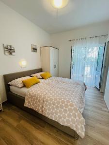 1 dormitorio con 1 cama grande con almohadas amarillas en Apartments with a parking space Palit, Rab - 4971, en Rab