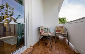 two chairs sitting on a balcony next to a window at Apartments with a parking space Palit, Rab - 4971 in Rab