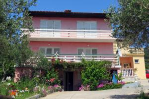 una casa rosa con dei fiori davanti di Family-friendly apartments with swimming pool Barbat, Rab - 4988 a Rab