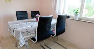 tavolo da pranzo con 4 sedie e tavolo con di Family-friendly apartments with swimming pool Barbat, Rab - 4988 a Rab