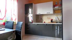 una cucina con mobili bianchi e un tavolo con sedie di Family-friendly apartments with swimming pool Barbat, Rab - 4988 a Rab