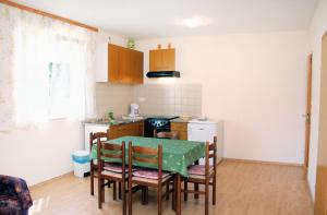 a kitchen with a table and chairs and a kitchen with a stove at Apartments with a parking space Kampor, Rab - 5029 in Kampor