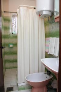 a bathroom with a shower curtain and a toilet and a sink at Apartments by the sea Supetarska Draga - Gonar, Rab - 4989 in Supetarska Draga