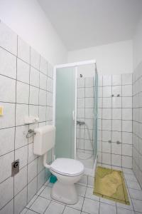 bagno bianco con servizi igienici e doccia di Apartments by the sea Kampor, Rab - 4986 a Rab