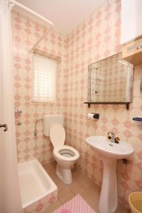 un baño con inodoro y lavabo en Apartments by the sea Barbat, Rab - 4978, en Barbat na Rabu 18 fotos más