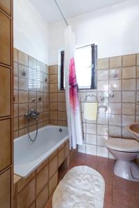 ein Badezimmer mit Badewanne, Toilette und Waschbecken in der Unterkunft Apartments by the sea Barbat, Rab - 4977 in Barbat na Rabu