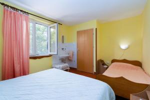 ein Schlafzimmer mit zwei Betten und einem Fenster in der Unterkunft Apartments by the sea Barbat, Rab - 4977 in Barbat na Rabu