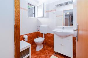 ein Badezimmer mit Toilette und Waschbecken in der Unterkunft Apartments by the sea Barbat, Rab - 4977 in Barbat na Rabu