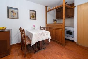 eine Küche mit Tisch und Herd oberen Backofen in der Unterkunft Apartments by the sea Barbat, Rab - 4977 in Barbat na Rabu + 23 Fotos