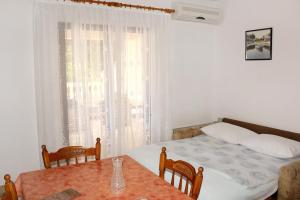 sypialnia z łóżkiem, stołem i oknem w obiekcie Apartments by the sea Zecevo Rtic, Rogoznica - 4839 w Rogoznicy