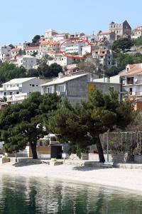 a couple of trees in front of a city at Apartments with parking spaces Igrane, Makarska - 4891 in Igrane