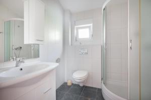 a white bathroom with a sink and a toilet at Apartments with parking spaces Igrane, Makarska - 4891 in Igrane +21 photos