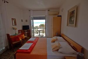 a bedroom with two beds and a table and a balcony at Apartments by the sea Selce, Crikvenica - 4801 in Selce