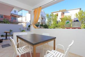 une table et des chaises sur le balcon d'une maison dans l'établissement Family friendly apartments with a swimming pool Podstrana, Split - 4859, à Podstrana