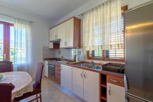 cocina con nevera, fregadero y mesa en Apartments and rooms with parking space Jelsa, Hvar - 4028, en Jelsa