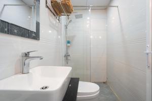 a bathroom with a sink and a toilet and a shower at De Charm Hạ Long Hotel in Ha Long
