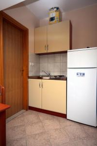 een keuken met een witte koelkast en een wastafel bij Apartments by the sea Duce, Omis - 4852 in Duće