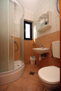 een badkamer met een douche, een toilet en een wastafel bij Apartments by the sea Duce, Omis - 4852 in Duće