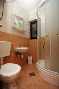 een badkamer met een toilet, een wastafel en een douche bij Apartments by the sea Duce, Omis - 4852 in Duće