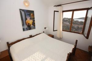 a bedroom with a bed and a large window at Apartments by the sea Sevid, Trogir - 5221 in Sevid