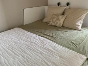 duże białe łóżko z 2 poduszkami w obiekcie Le Panima w mieście Palavas-les-Flots