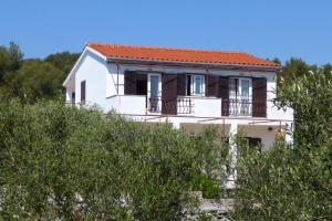 a white house with an orange roof at Apartments with parking space Maslinica, Solta - 5184 in Grohote