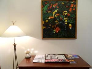 a table with a lamp and a painting on the wall at City Lodge Bangkok in Bangkok