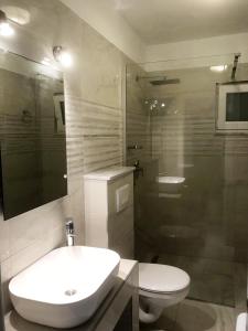 ein Bad mit einem Waschbecken, einem WC und einer Dusche in der Unterkunft Seaside apartments with a swimming pool Rogac, Solta - 5183 in Grohote