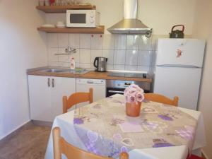 una cucina con tavolo e frigorifero bianco di Apartments by the sea Rogac, Solta - 5166 a Grohote